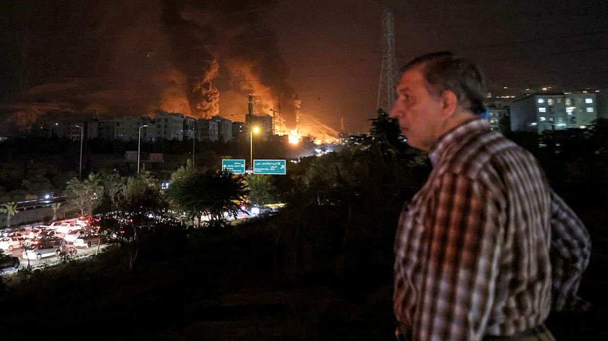 Iranian man watches traffic amid Israeli attacks