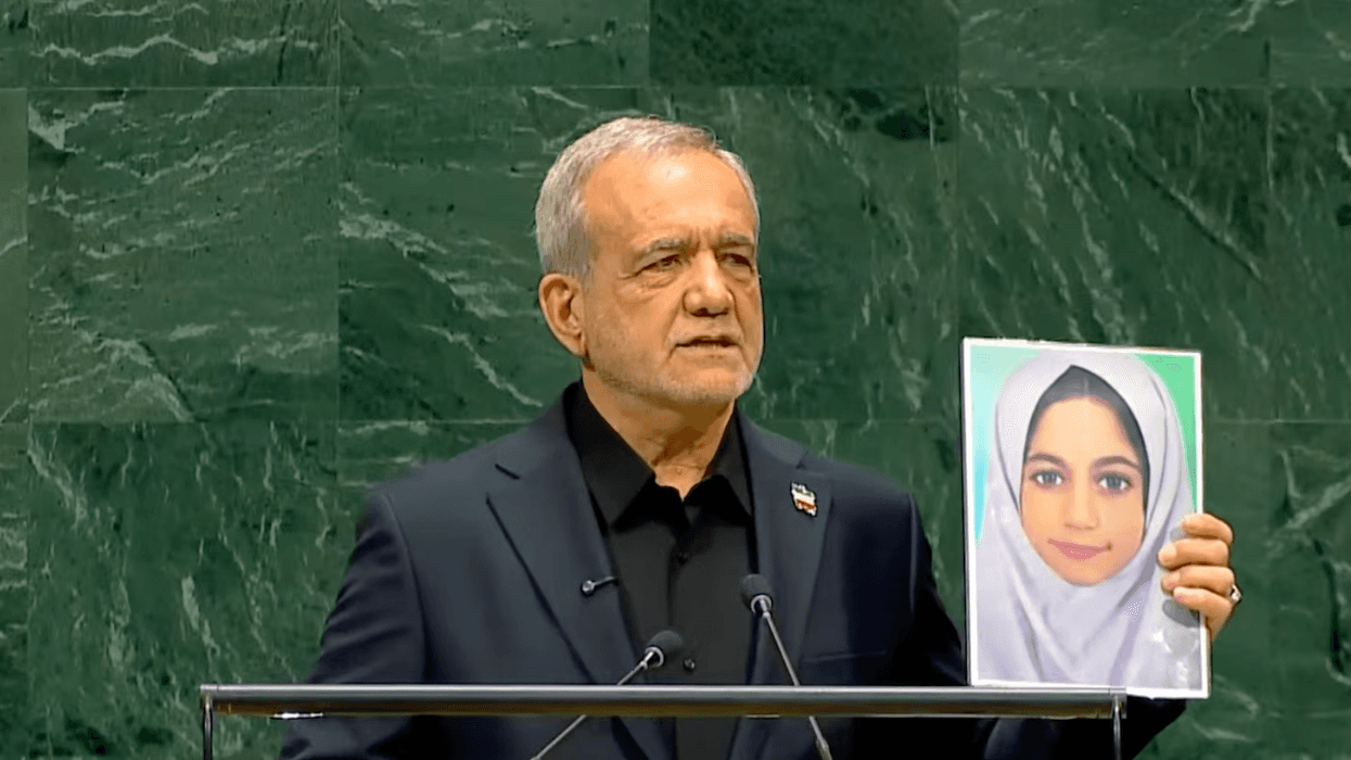 Iranian President Masoud Pezeshkian holds a photo of one of the 120 children killed in the Minab school strike