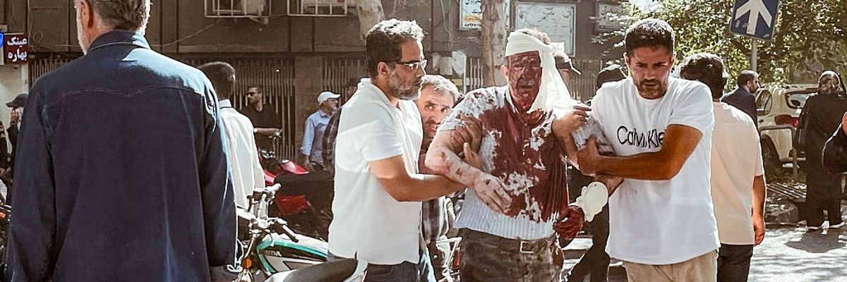 Iranians aid people injured by an Israeli airstrike