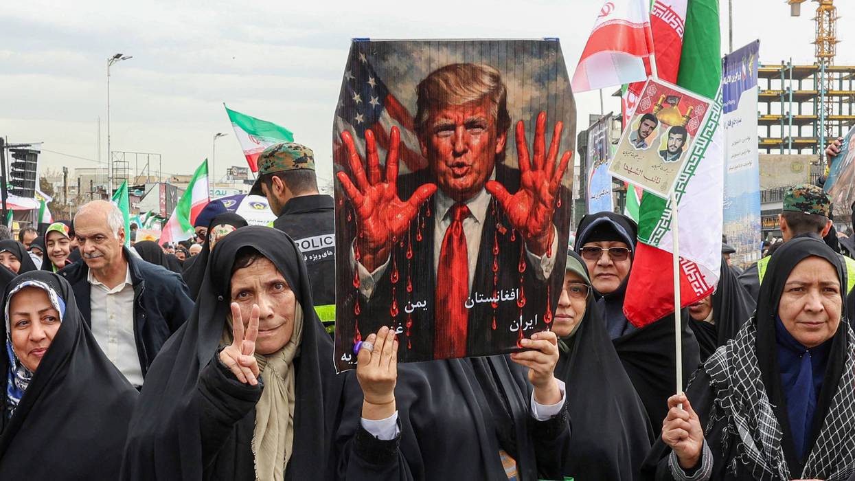 Iranians protest Trump, who is shown on a placard with bloody hands