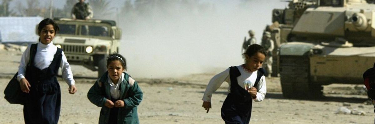 Iraqi schoolgirls flee an approaching US army patrol in the Baghdad suburb of Abu Gharib