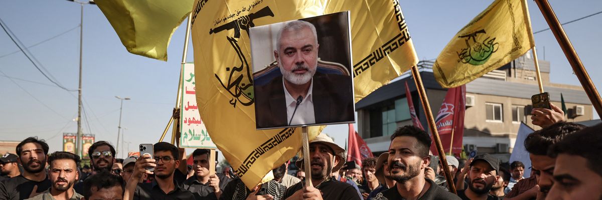 Iraqis raise a picture of assassinated Hamas leader Ismail Haniyeh