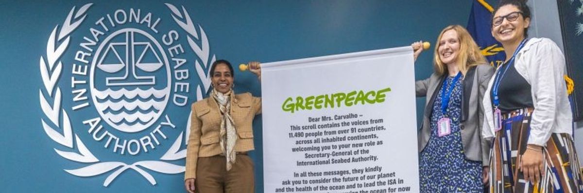 ISA Secretary-General Leticia Carvalho is presented a scroll by Greenpeace activists.