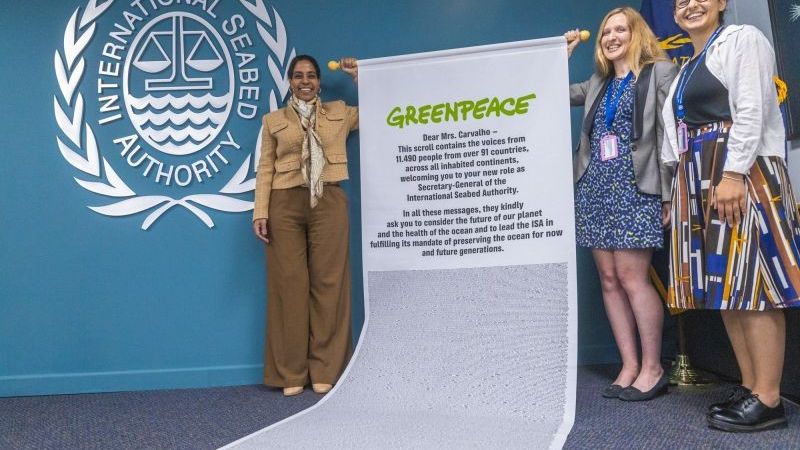 ISA Secretary-General Leticia Carvalho is presented a scroll by Greenpeace activists.