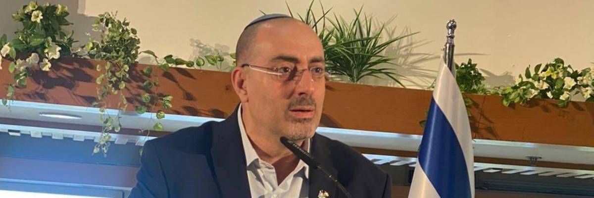 Israeli Deputy Knesset Speaker Nissim Vaturi delivers a speech beside an Israeli flag