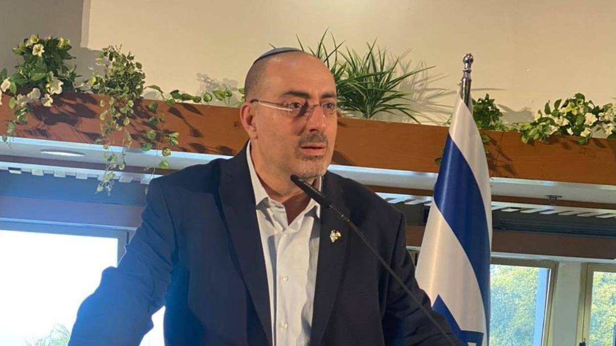 Israeli Deputy Knesset Speaker Nissim Vaturi delivers a speech beside an Israeli flag
