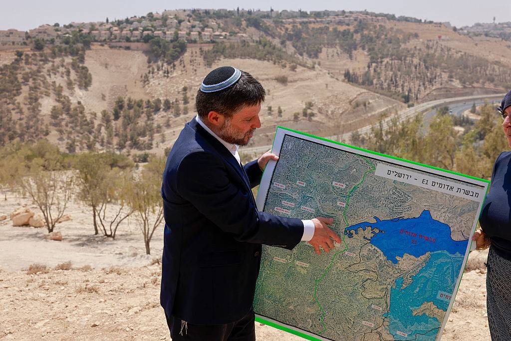 Israeli Finance Minister Bezalel Smotrich holds a map of an area known as E1