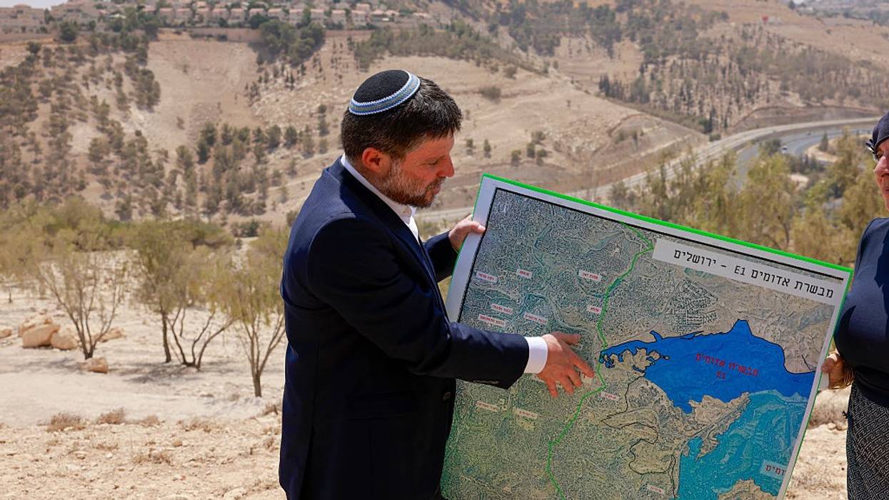 Israeli Finance Minister Bezalel Smotrich holds a map of an area known as E1