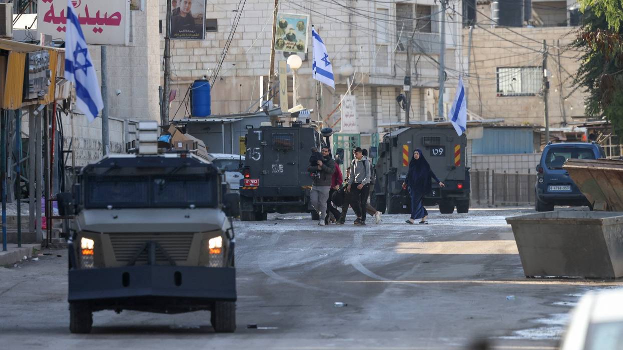 Israeli forces in armored vehicles conduct a raid in Jenin.