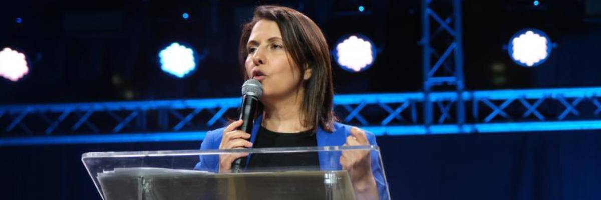 Israeli Intelligence Minister Gila Gamliel hold a microphone while speaking on a stage