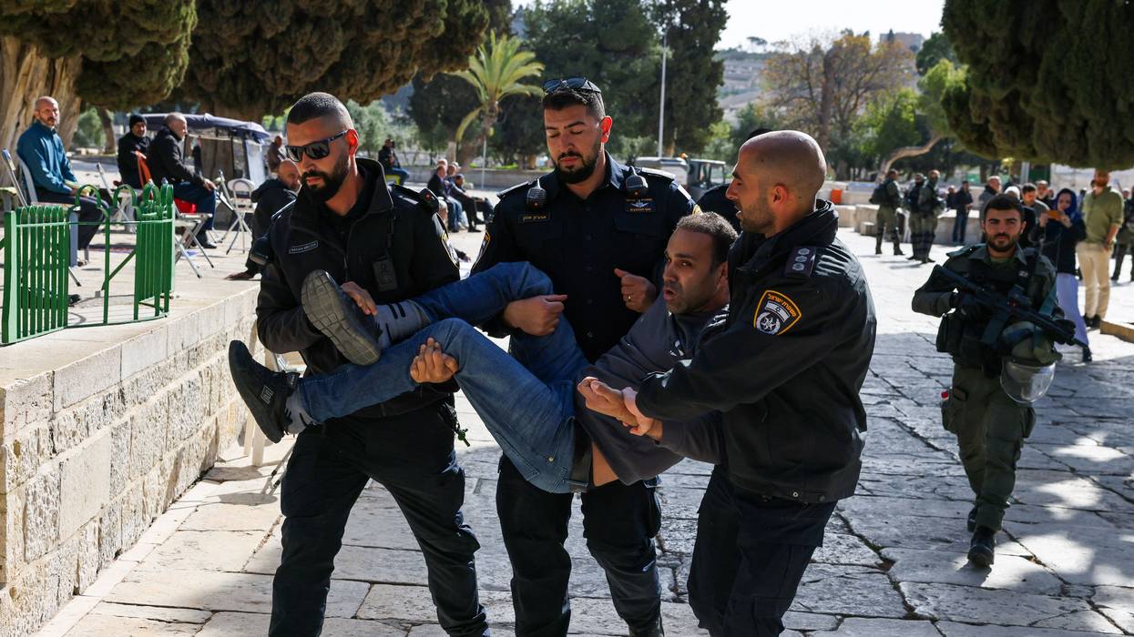 Israeli police officers detain a Palestinian man at the Al-Aqsa Mosque compound following a raid on the holy site in occupied East Jerusalem on April 5, 2023.