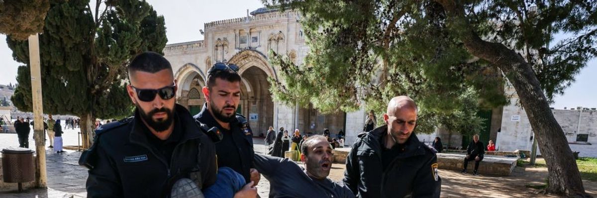 Israeli policemen detain a Palestinian man at the Al-Aqsa Mosque