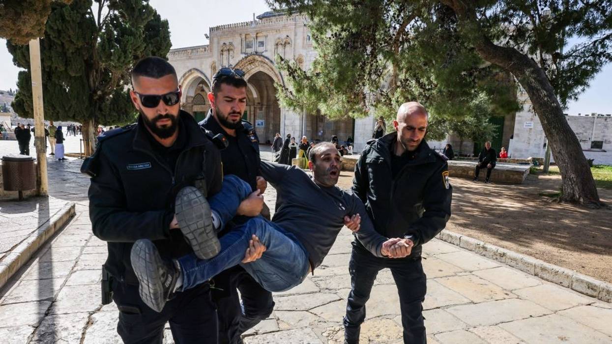 Israeli policemen detain a Palestinian man at the Al-Aqsa Mosque