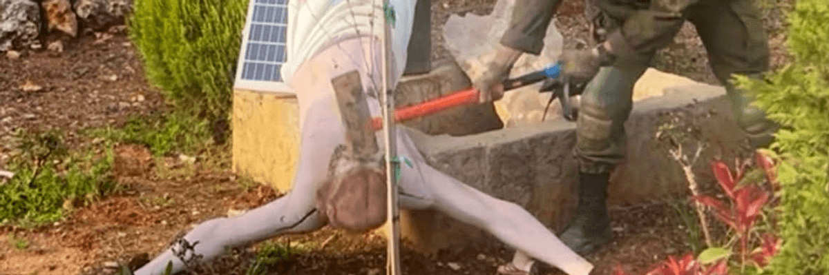Israeli soldier smashes head of Christ statue.