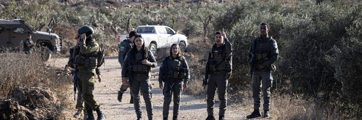 Israeli soldiers block the road to prevent Palestinian farmers from reaching their land