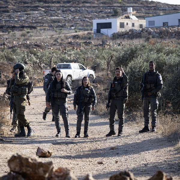 Israeli soldiers block the road to prevent Palestinian farmers from reaching their land