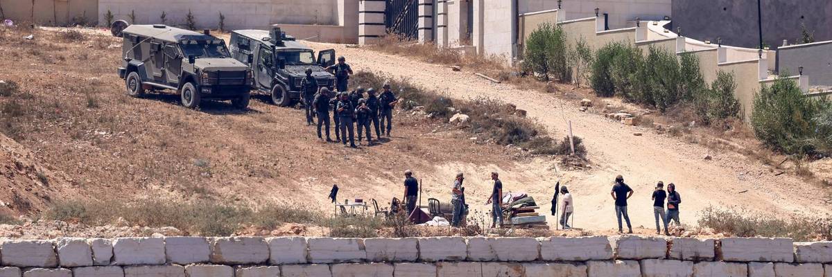 Israeli soldiers guard settlers in the West Bank.