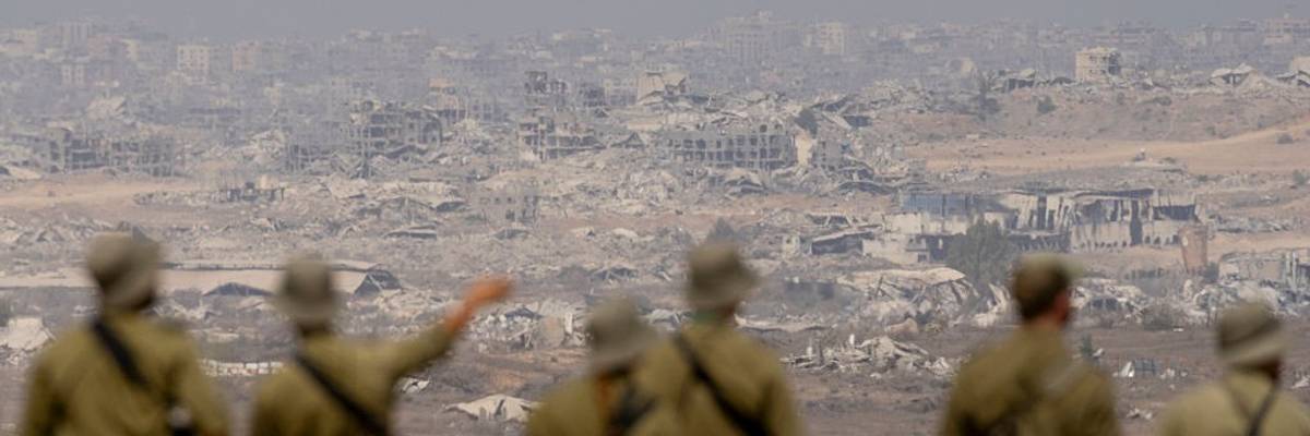 Israeli soldiers look out on a destroyed Gaza