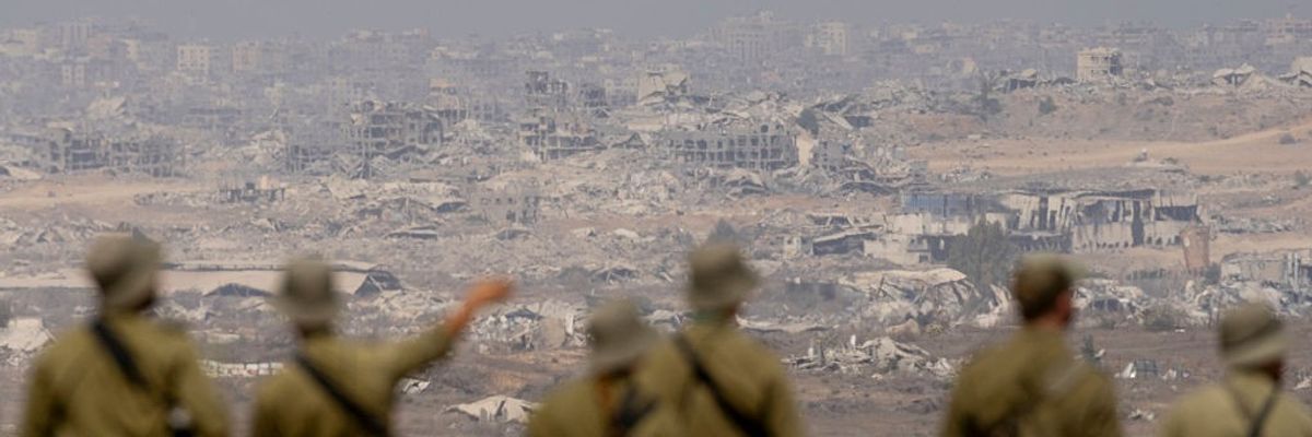 Israeli soldiers look out on a destroyed Gaza