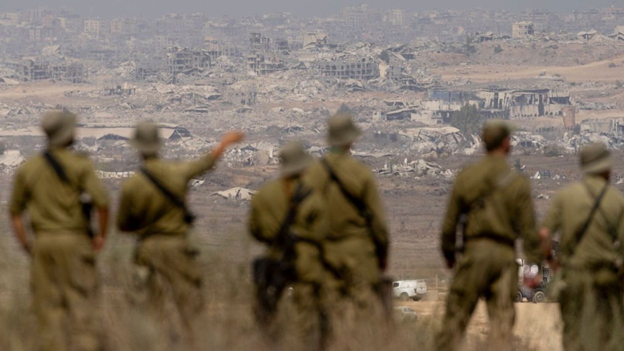 Israeli soldiers look out on a destroyed Gaza