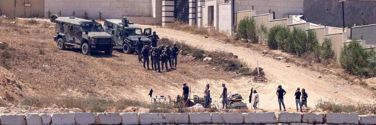 Israeli soldiers stand guard in Qusra.