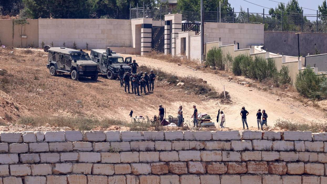 Israeli soldiers stand guard in Qusra.