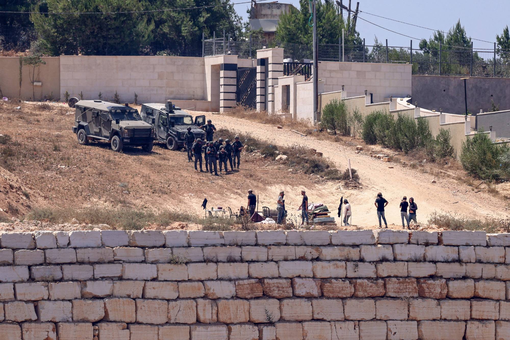 Israeli soldiers stand guard in Qusra.