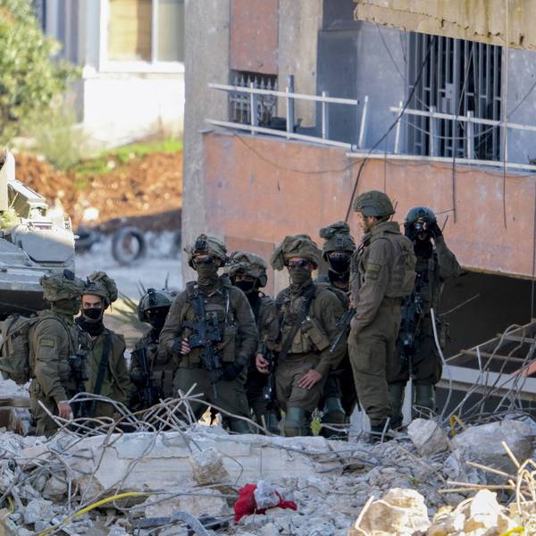 Israeli soldiers stand near a damaged building in southern Lebanon