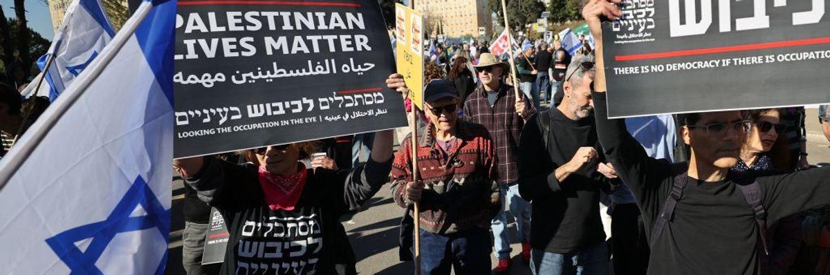 Israelis carry banners and flags as they gather in front of the the Knesset