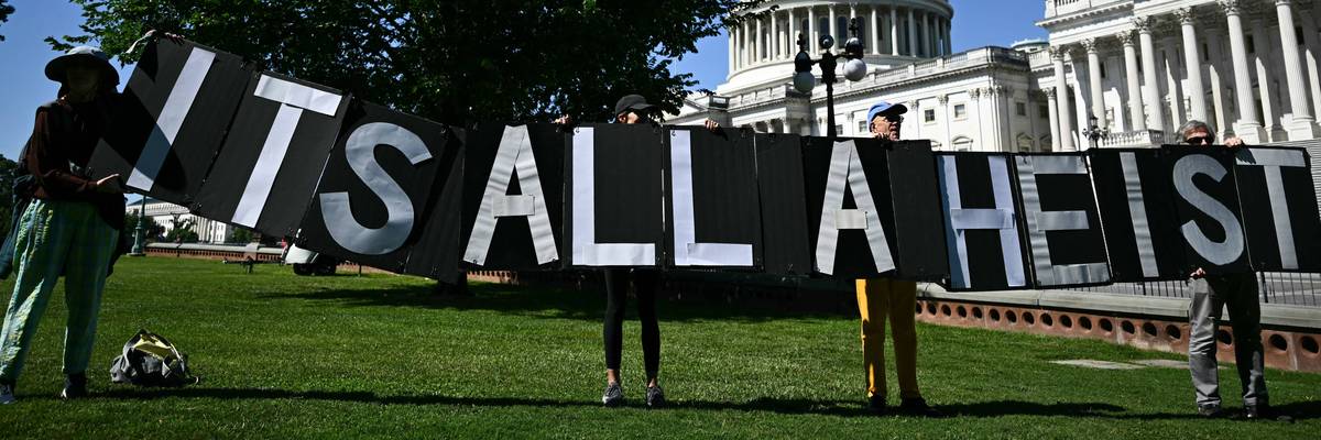 "It's all a heist" signs says at Trump protest