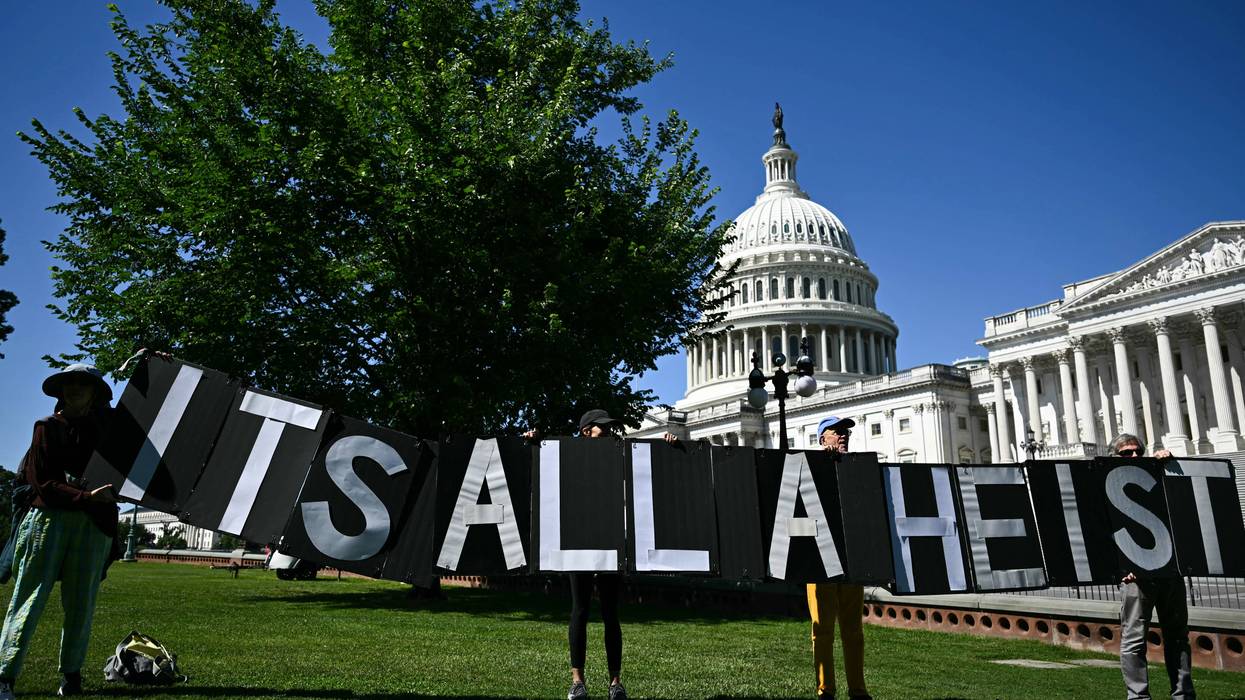 "It's all a heist" signs says at Trump protest