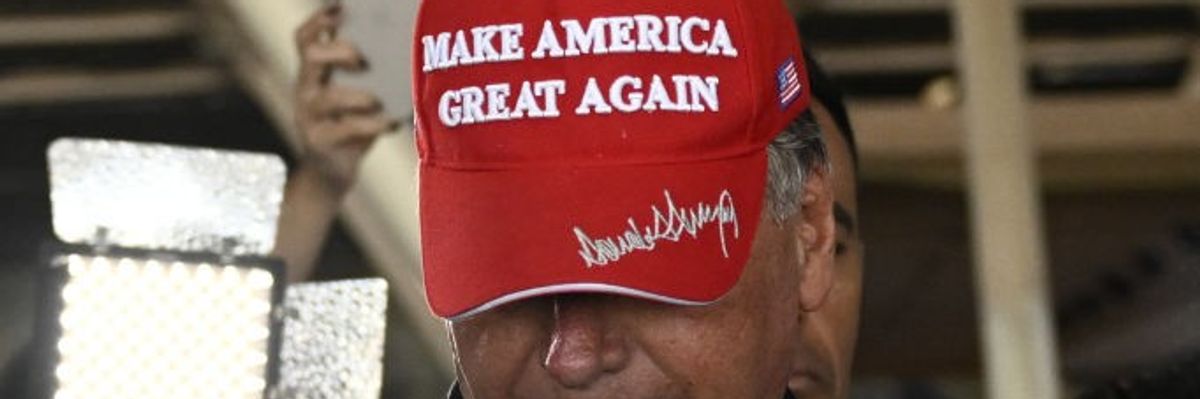 Jair Bolsonaro wears a signed maga hat