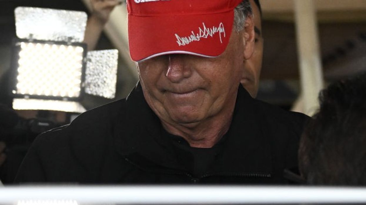 Jair Bolsonaro wears a signed maga hat