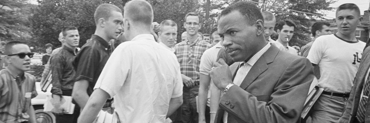 James Meredith walks across the Ole Miss campus amidst stares and jeers of white fellow students. 