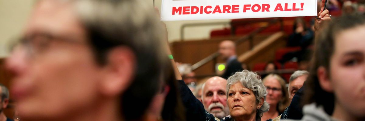 Jamie Sheldon holds a Medicare for All sign as she listens to House Speaker Nancy Pelosi (D-Calif.) address an audience during a town hall meeting on gun violence at Lincoln High School in San Francisco on August 27, 2019