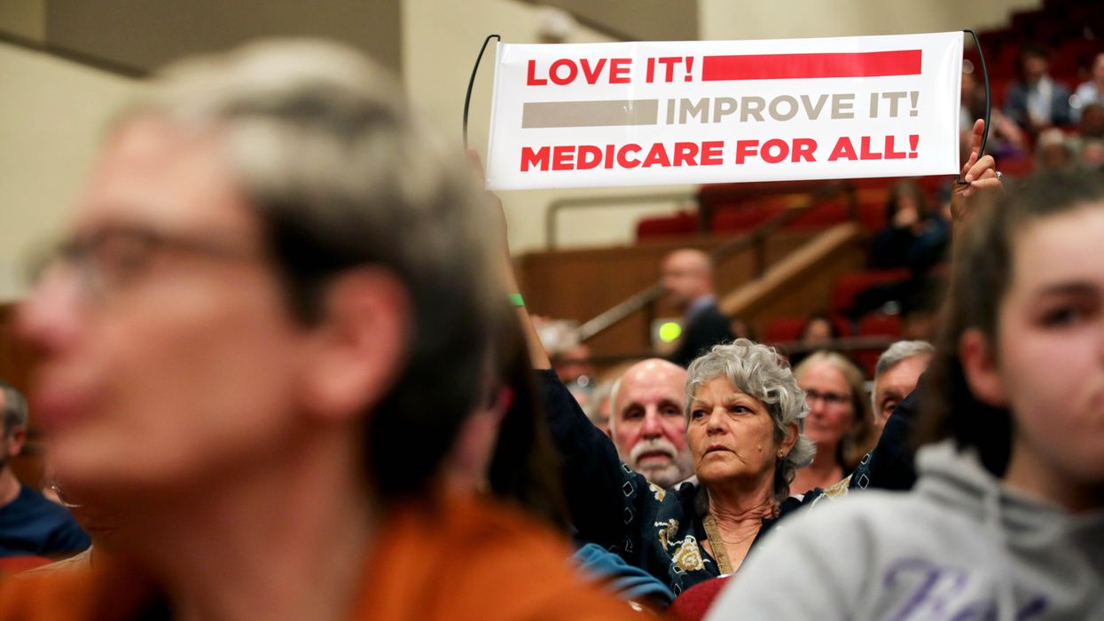 Jamie Sheldon holds a Medicare for All sign as she listens to House Speaker Nancy Pelosi (D-Calif.) address an audience during a town hall meeting on gun violence at Lincoln High School in San Francisco on August 27, 2019