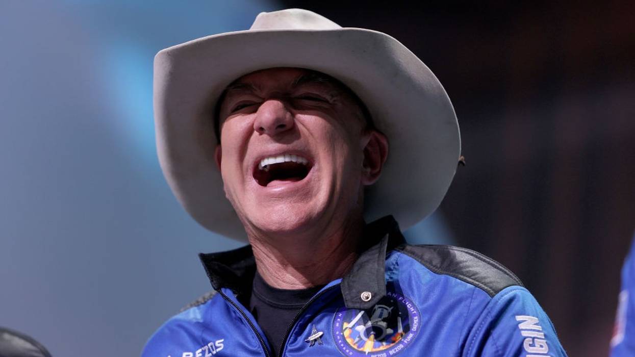 Jeff Bezos laughs during a press conference