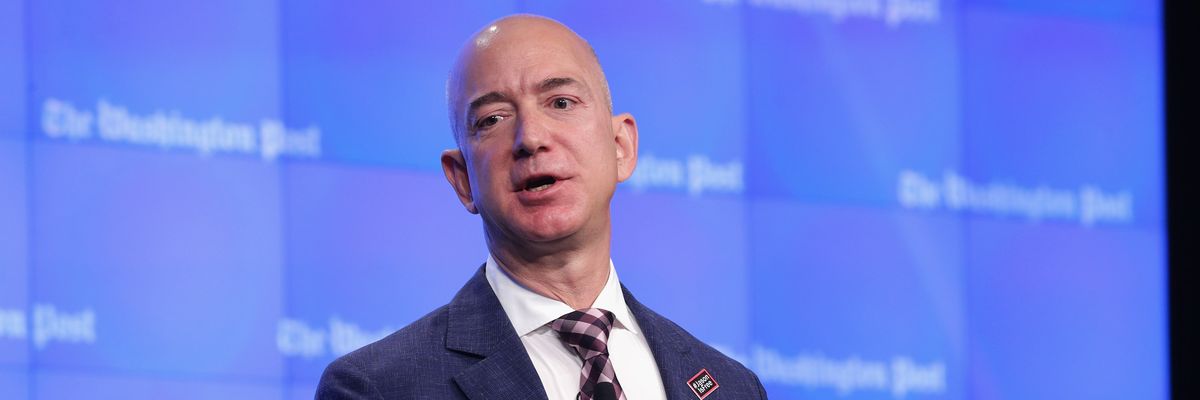 Jeff Bezos speaks against a blue background with Washington Post written in white letters.