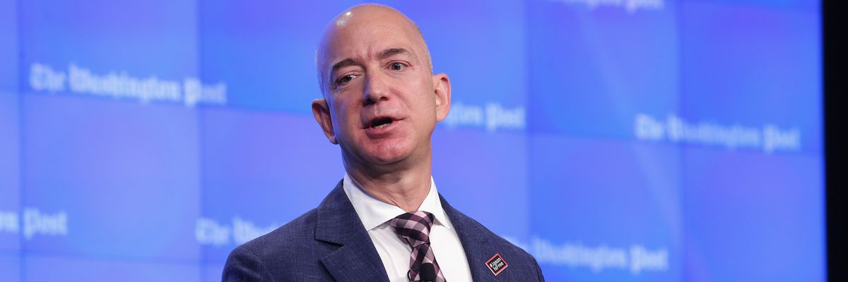 Jeff Bezos speaks against a blue background with Washington Post written in white letters.