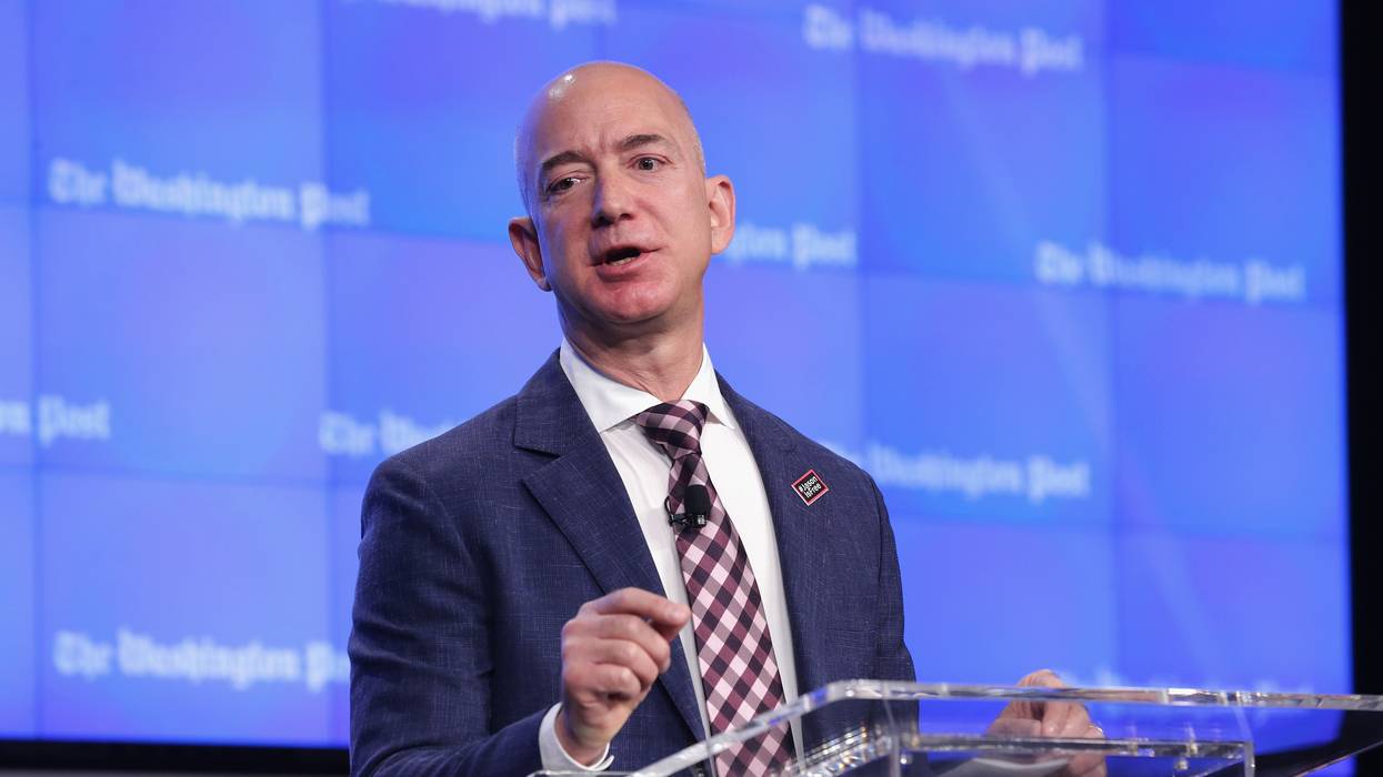 Jeff Bezos speaks against a blue background with Washington Post written in white letters.