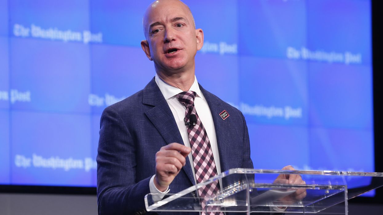 Jeff Bezos speaks against a blue background with Washington Post written in white letters.