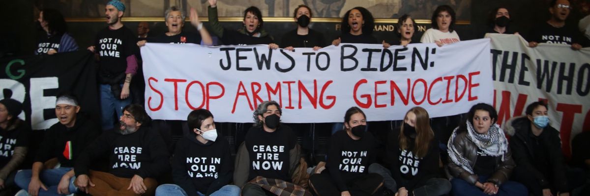 Jewish Voice for Peace activists hold a banner reading, "Jews to Biden: Stop Arming Genocide." 