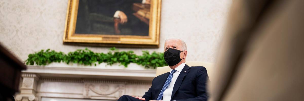 Joe Biden sitting beneath portrait of FDR