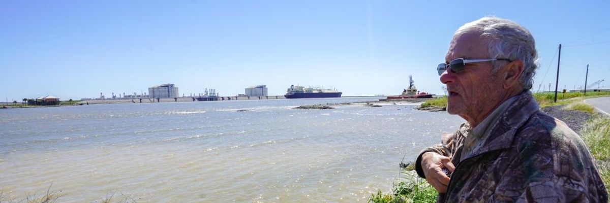 John Allaire stands in profile with water and LNG infrastructure in the background.