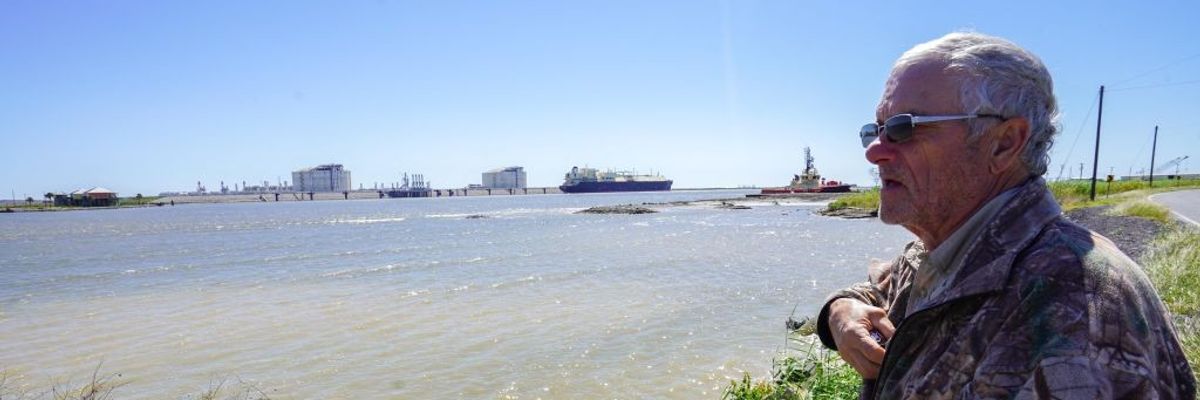 John Allaire stands in profile with water and LNG infrastructure in the background.