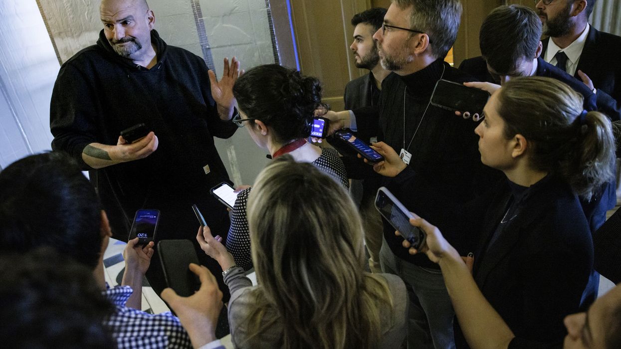 John Fetterman talks to reporters.