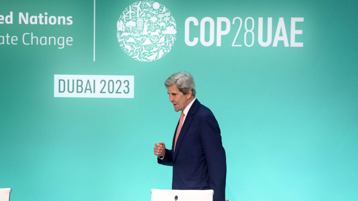 John Kerry walks with a clenched fist at COP28.