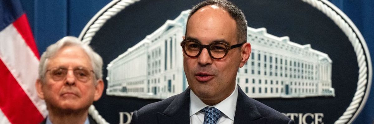 Jonathan Kanter speaks while Merrick Garland stands by