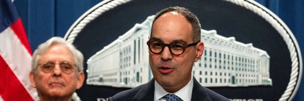 Jonathan Kanter speaks while Merrick Garland stands by