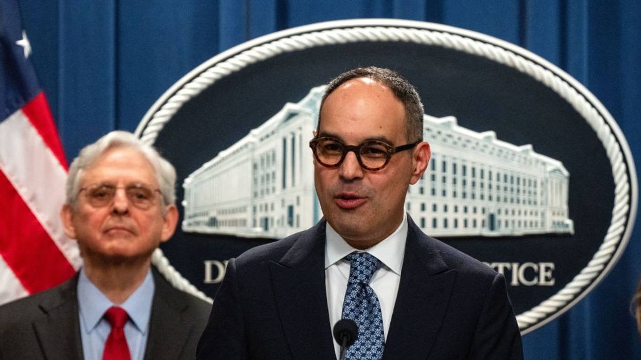 Jonathan Kanter speaks while Merrick Garland stands by